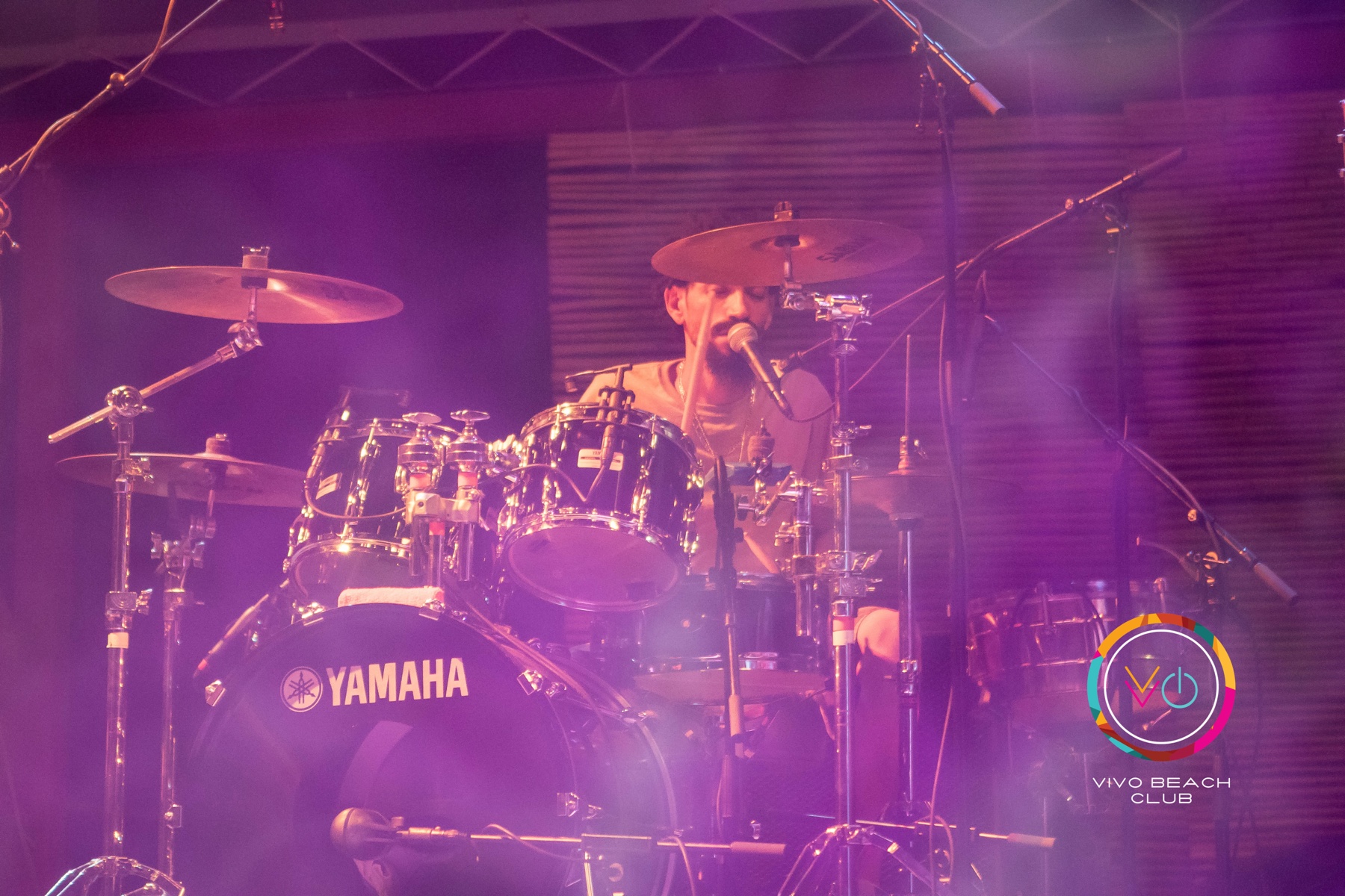 The Wailers drummer performing under purple stage lighting at Vivo Beach Club