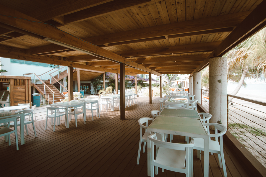 Covered Voodoo Deck seating beside the beach at Vivo Beach Club