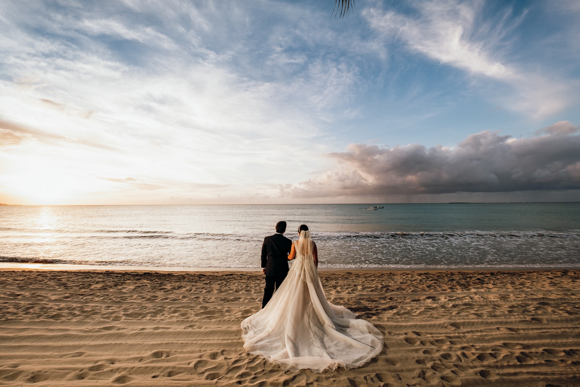 Bride and groom standing on the beach at Vivo Beach Club with ocean views at sunset