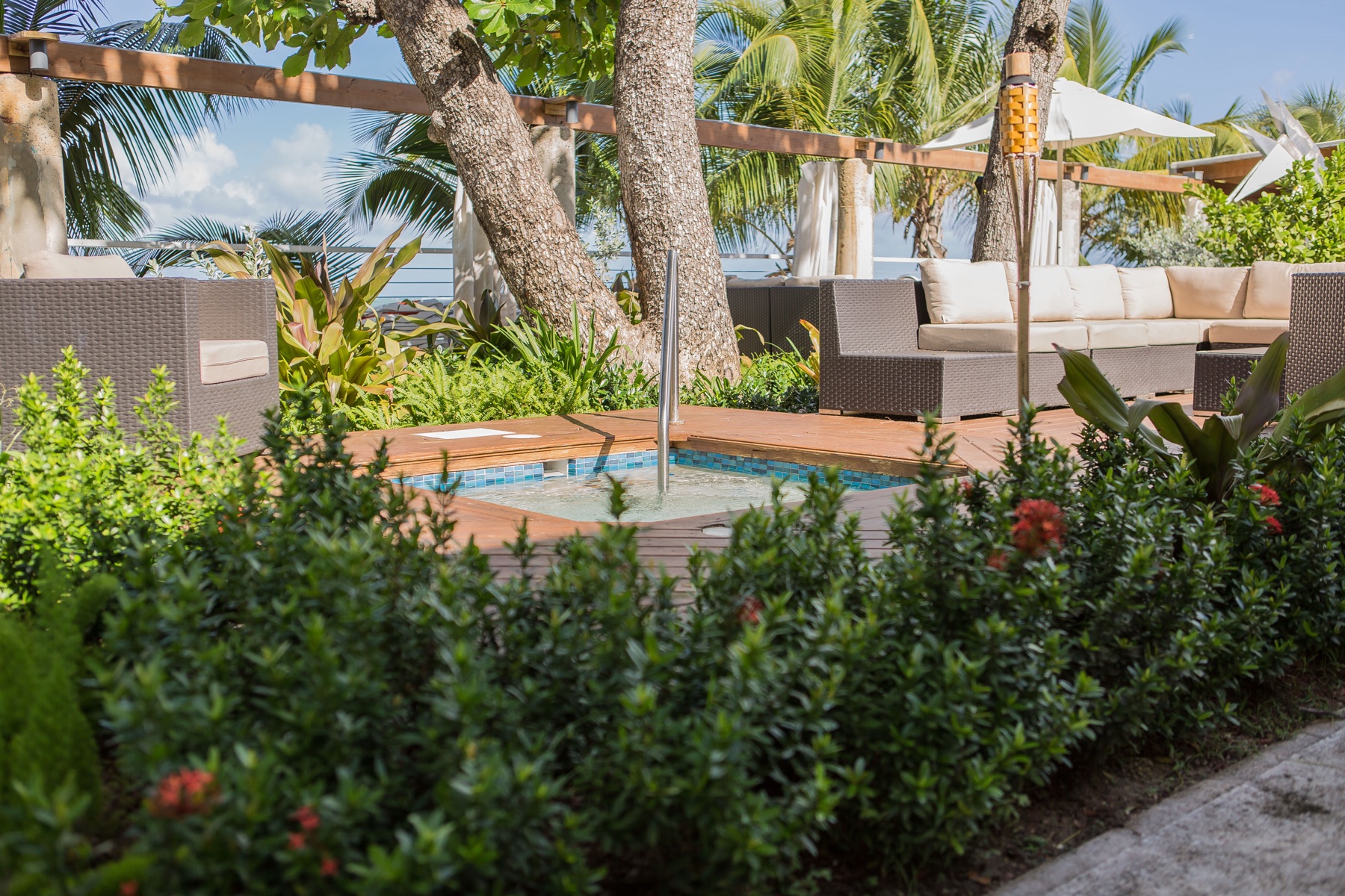 Outdoor lounge seating at Vivo Beach Club surrounded by tropical landscaping